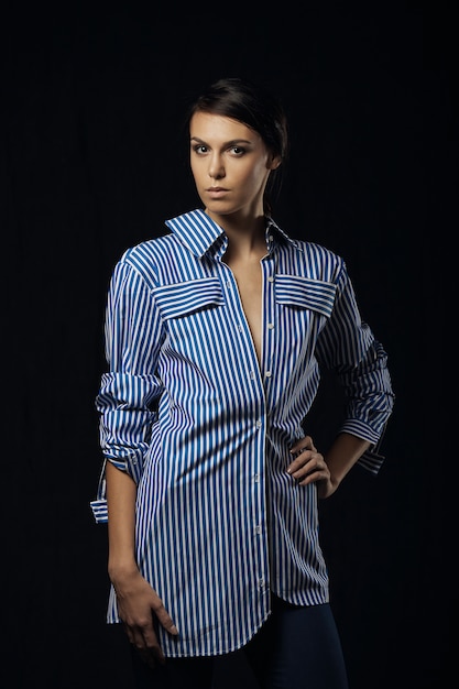 Fashion photo of young magnificent woman in blue shirt