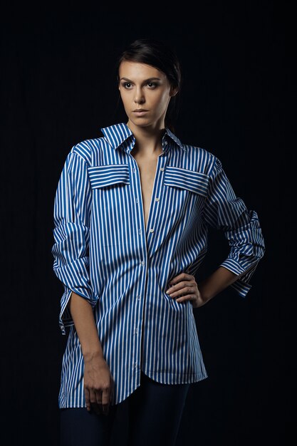 Fashion photo of young magnificent woman in blue shirt