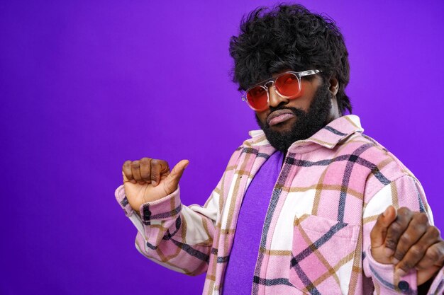 Fashion portrait of african american man in glasses against purple background