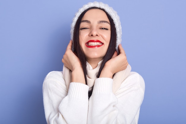 Fashion portrait of beautiful happy young woman with dark long hair and bright makeup, female stands smiling