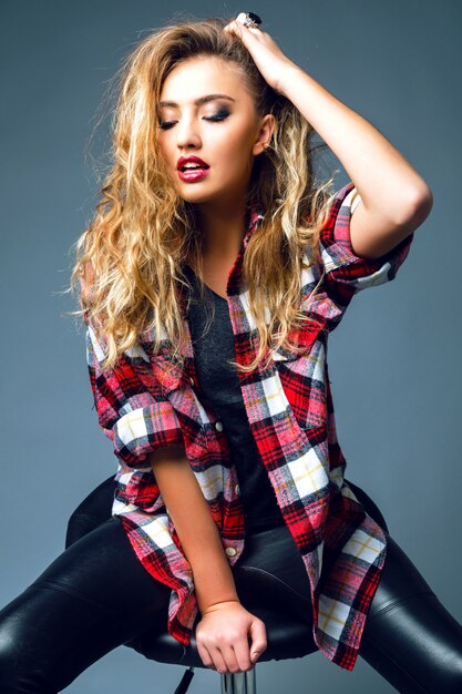 Fashion portrait of beautiful woman with amazing hairs and beautiful face, wearing bright smoky rock makeup, and big relaxed grunge plaid shirt.