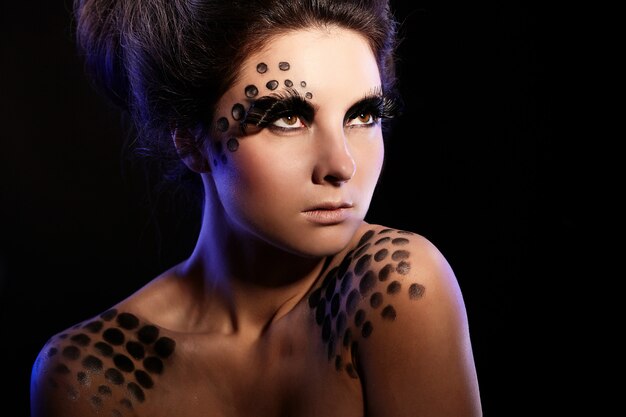 fashion portrait of confident woman with bright black makeup and unusual hairstyle