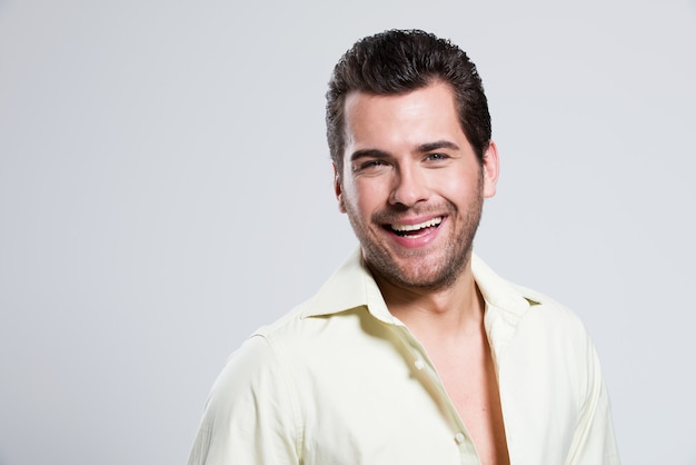 Fashion portrait of handsome happy man in yellow shirt poses 