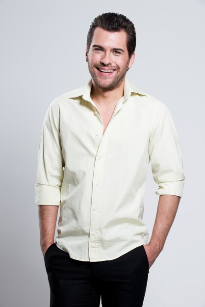 Fashion portrait of handsome happy man in yellow shirt poses 