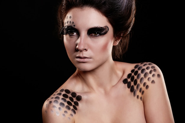 fashion portrait of serious woman with bright black makeup and unusual hairstyle