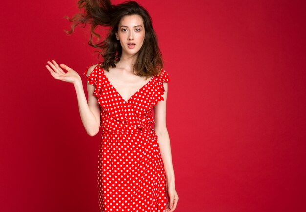 빨간색에 빨간색 점선 드레스에 웃는 젊은 여자의 패션 초상화