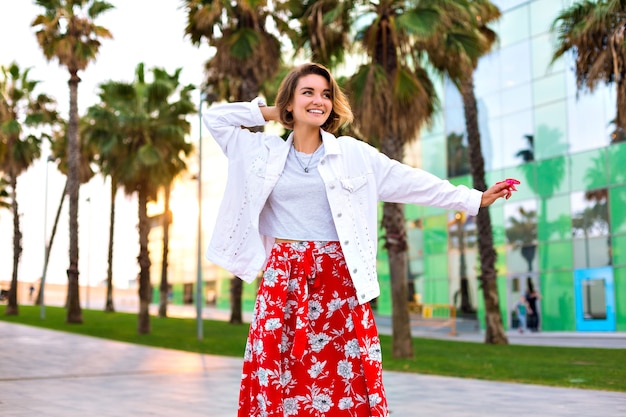 Fashion portrait of stylish woman posing at Barcelona street, palms around, neon sunglasses, traveling mood, casual hipster outfit, joy, free spirit.