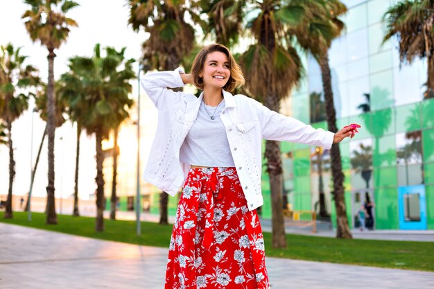 Fashion portrait of stylish woman posing at Barcelona street, palms around, neon sunglasses, traveling mood, casual hipster outfit, joy, free spirit.