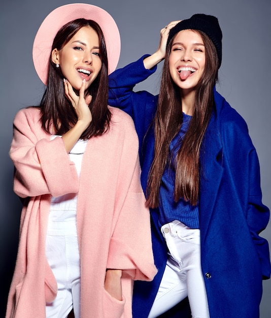 fashion portrait of two smiling brunette women models in summer casual hipster overcoat posing 