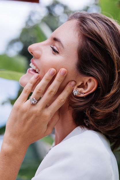 Free photo fashion portrait of woman at tropical luxury villa wearing white stylish blazer and jewellery over tropical leaves