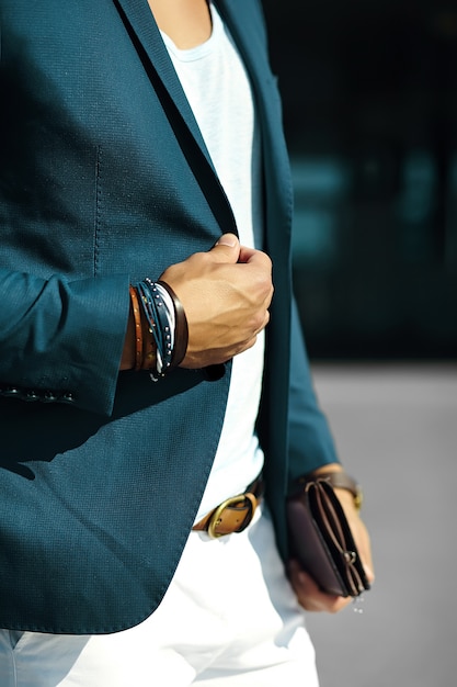 Fashion portrait of young businessman handsome  model man in casual cloth suit with accesories on hands