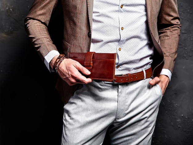Фасонируйте портрет молодого бизнесмена красивого модельного человека одетого в элегантном коричневом костюме с аксессуарами