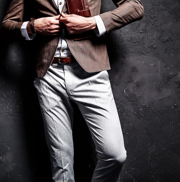 Fashion portrait of young businessman handsome model man dressed in elegant brown suit with accessories