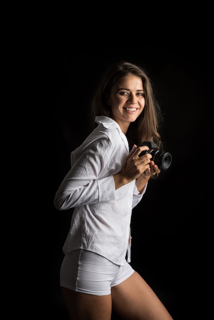 カメラを持つ若い女性写真家のファッションの肖像画
