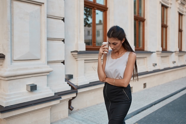 Adatti la donna graziosa che cammina per le vie di città vecchia