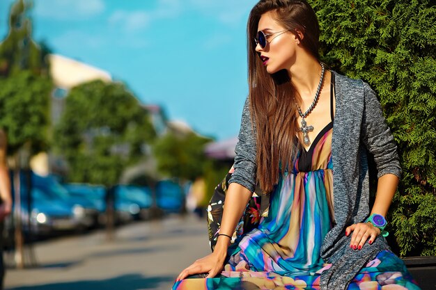 fashion stylish beautiful young brunette woman model in summer hipster colorful casual clothes posing on street