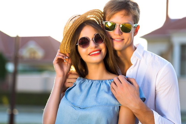 Fashion summer image of elegant vintage styled couple in romantic valentine day, having great time together, hugs and kisses, hipsters, stylish clothes and sunglasses, beautiful lovers, family outdoor