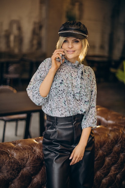 Free photo fashion woman in a cafe talking on the phone