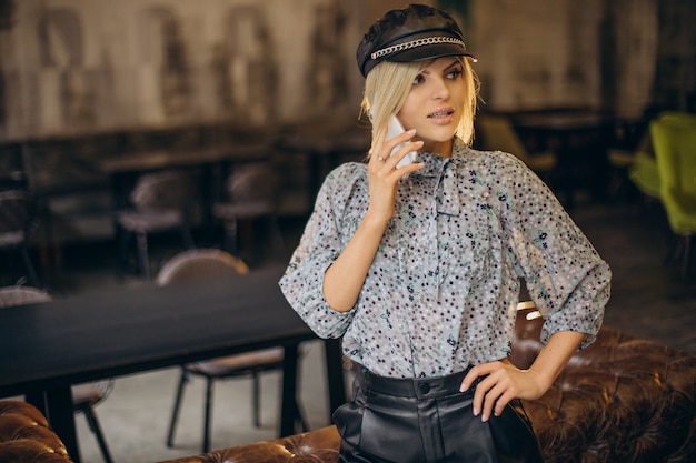 Fashion woman in a cafe talking on the phone