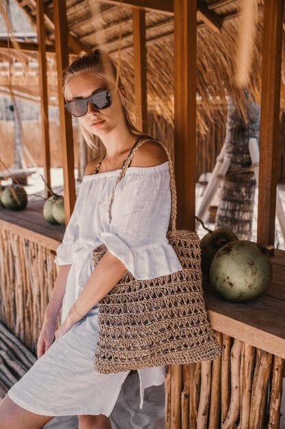 Free photo fashion woman in white behind a wooden cafe