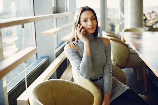 Fashion young girl sitting in a cafe