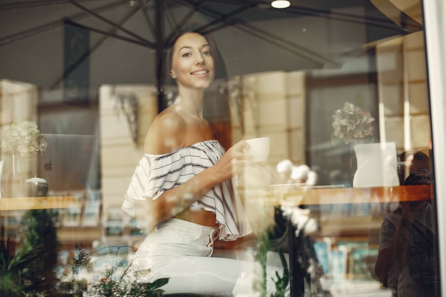 Adatti la ragazza in un caffè dell'estate