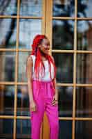 Free photo fashionable african american girl at pink pants and red dreads posed outdoor