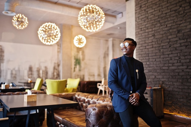 Free photo fashionable african american man in suit and glasses posed at cafe