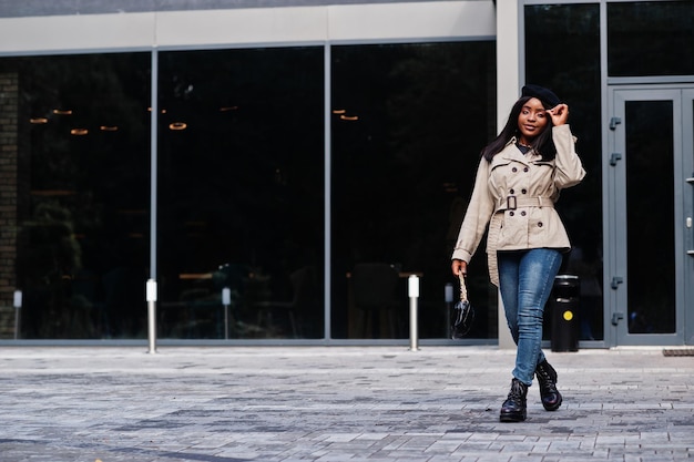 Free photo fashionable african american woman wear beret and coat with handbag posing outdoor