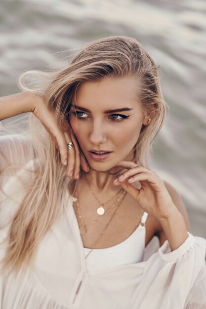 Fashionable blond model posing on the beach