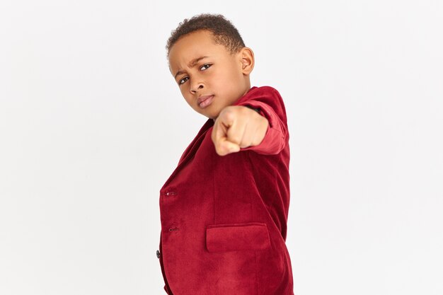 Fashionable child with red blazer pointing to the front