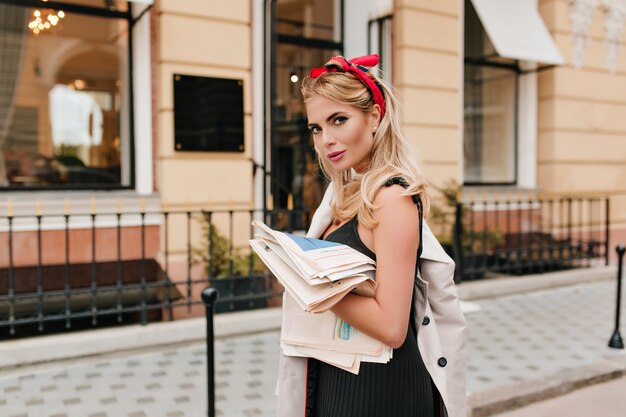 Fashionable european girl with red ribbon in hair looking with gently smile