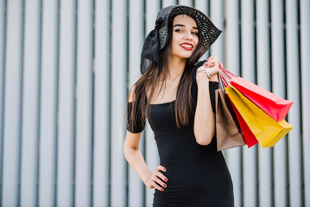 Free photo fashionable girl holding shopping bags smiling