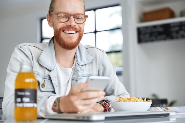 Fashionable hipster guy dressed in denim shirt and wearing stylish glasses