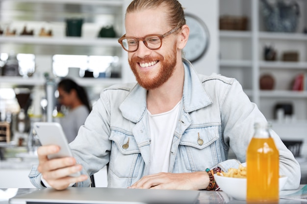 Fashionable hipster guy dressed in denim shirt and wearing stylish glasses