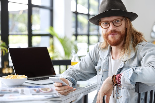 Free photo fashionable hipster guy dressed in stylish black hat and denim shirt