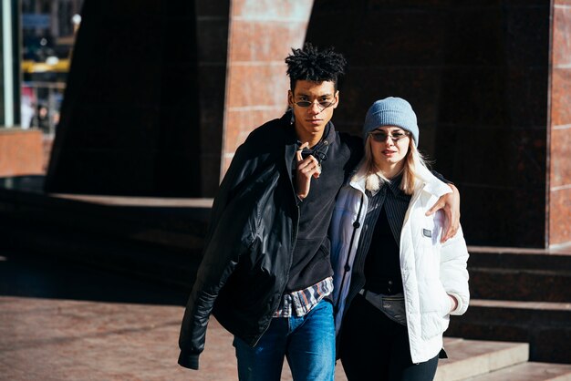 Fashionable interracial young couple looking at camera