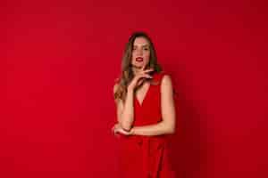 Free photo fashionable lovely woman in red dress posing
