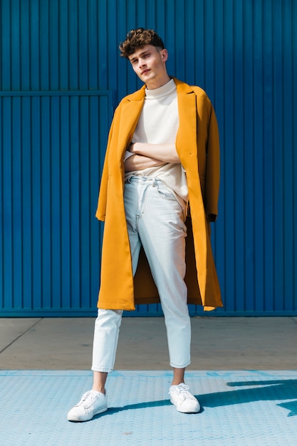 Fashionable man in front of blue wall