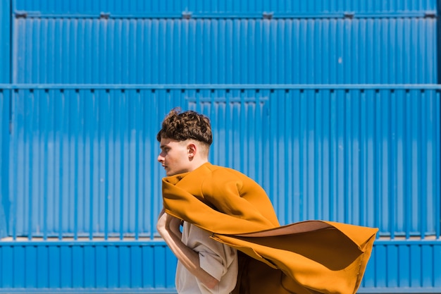 Free photo fashionable man in front of blue wall