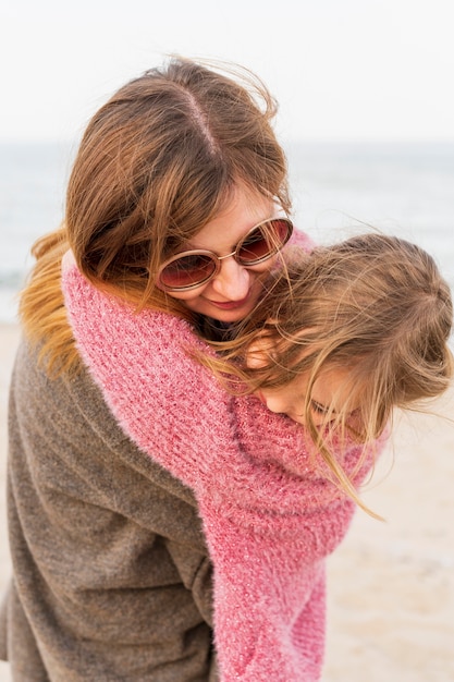 Fashionable mother holding daughter close up