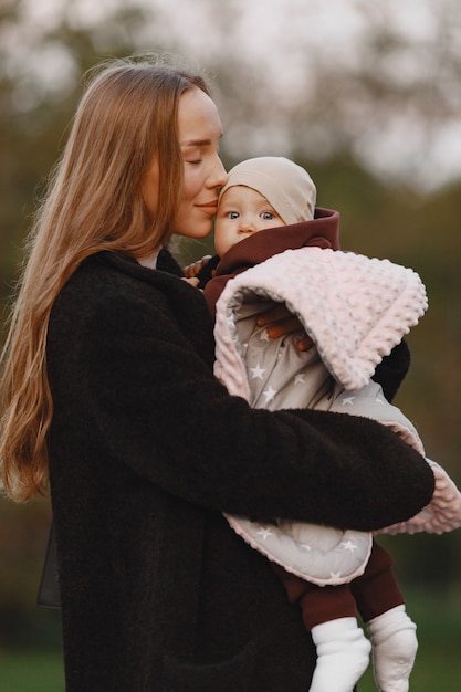 Madre alla moda con la figlia. la gente cammina fuori. donna in una giacca nera.