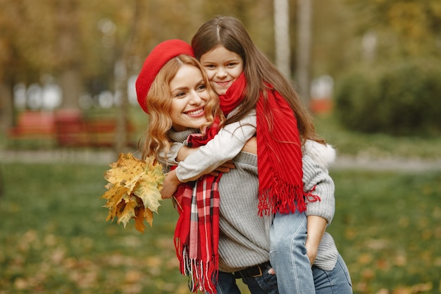 Модная мать с дочерью. Желтая осень. Женщина в красном шарфе.