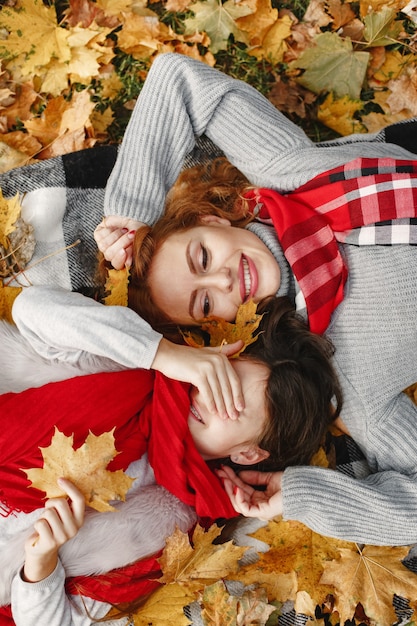 Fashionable mother with daughter. Yellow autumn. Woman in a red scarf.