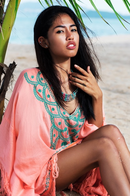 Fashionable portrait of asian woman posing on the tropical beach