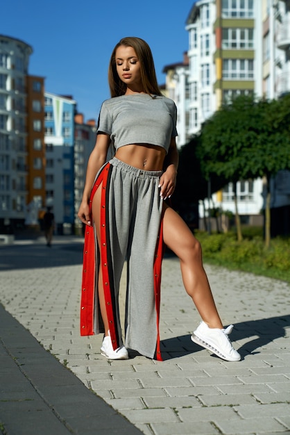 Free photo fashionable sporty woman posing near multistorey buildings