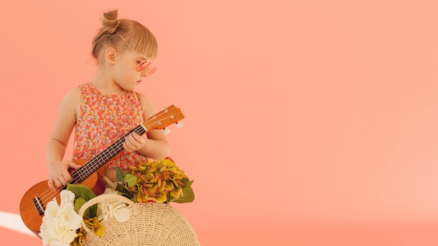 Fashionable toddler holding guitar