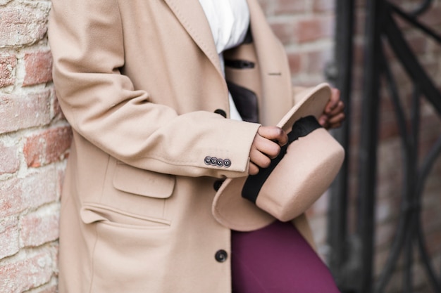 fashionable woman holding her hat down