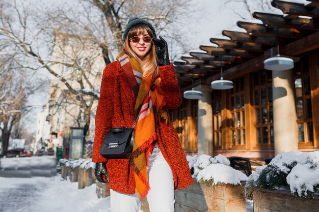 Fashionable woman in stylish winter outfit walking around the city