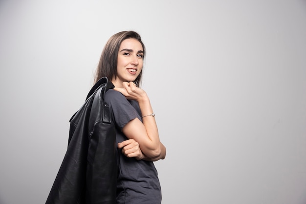 Fashionable young beautiful woman posing in black leather jacket.